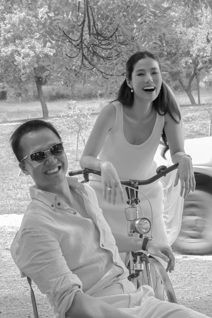Có thể là hình ảnh đen trắng về 2 người, mọi người đang cười, xe môtô và xe đạp